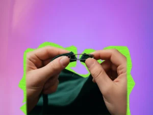 A close-up broken costume strap fix in action, using a single safety pin on a dark green velvet dress.